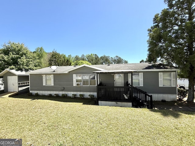 manufactured / mobile home featuring roof with shingles and a front lawn