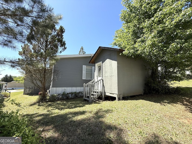 view of front of property with entry steps and a front lawn