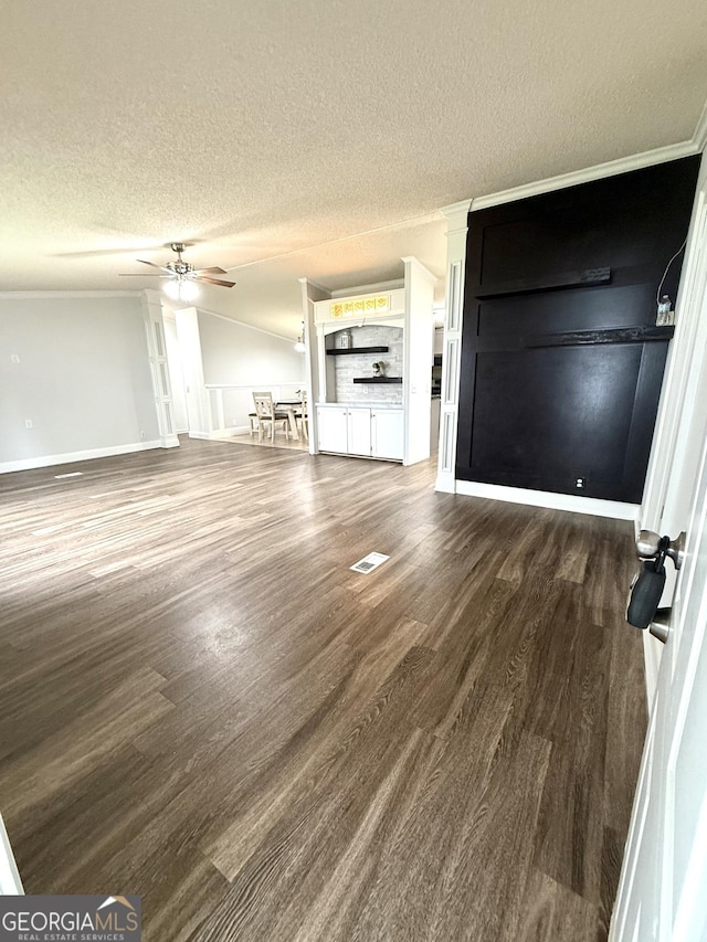 750 Six Flags Rd Lot 417, Austell, GA 30168 - unfurnished living room featuring dark wood finished floors, a ceiling fan, a textured ceiling, baseboards, and crown molding