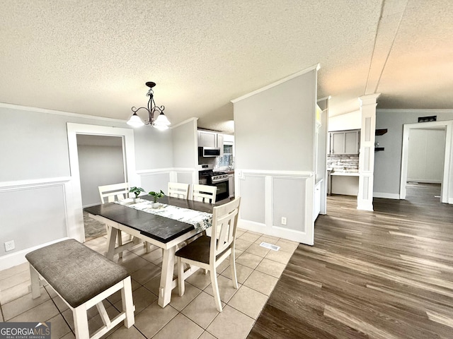 750 Six Flags Rd Lot 417, Austell, GA 30168 - dining space featuring crown molding, a chandelier, light wood-style flooring, a textured ceiling, and wainscoting
