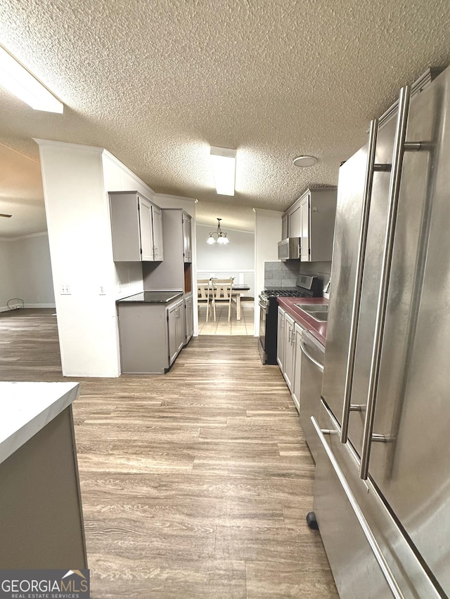 750 Six Flags Rd Lot 417, Austell, GA 30168 - kitchen featuring stainless steel appliances, gray cabinets, light wood-style floors, dark countertops, and a textured ceiling