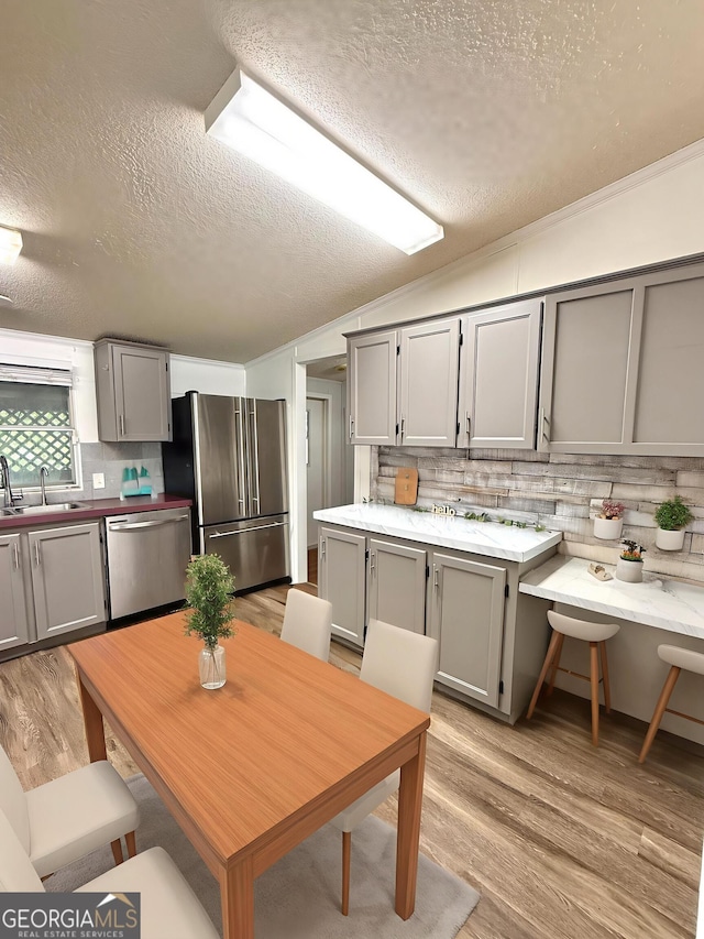 750 Six Flags Rd Lot 417, Austell, GA 30168 - kitchen with stainless steel appliances, a sink, a textured ceiling, gray cabinetry, and backsplash