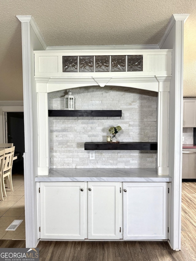 750 Six Flags Rd Lot 417, Austell, GA 30168 - bar area featuring crown molding, a textured ceiling, backsplash, and dark wood-type flooring