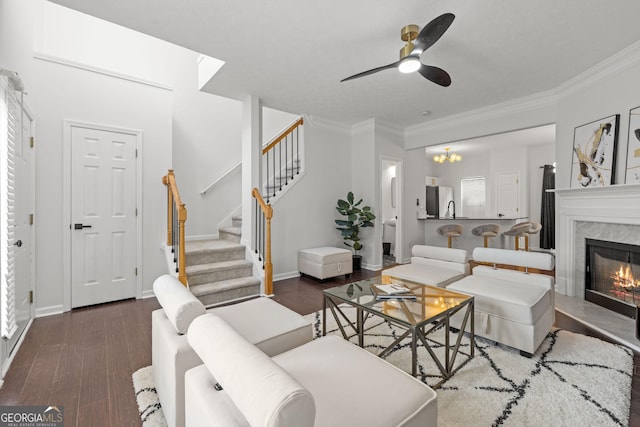 112 Timber Mist Ln, Lawrenceville, GA 30045 - living area with crown molding, ceiling fan with notable chandelier, stairs, a high end fireplace, and dark wood-style floors