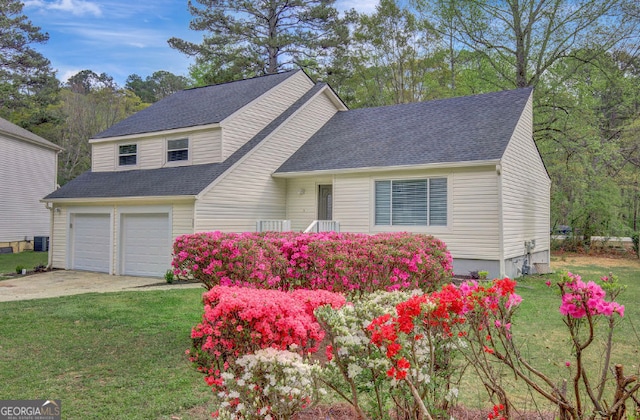 view of front of property featuring roof with shingles, driveway, a front lawn, and an attached garage