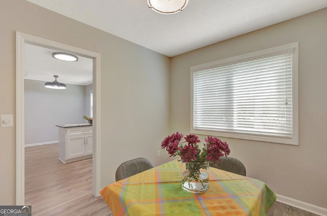 dining room featuring baseboards and light wood-type flooring