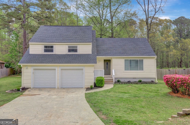 split level home featuring concrete driveway, a front yard, fence, and an attached garage