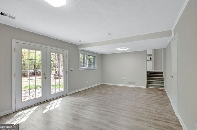 interior space featuring french doors, visible vents, light wood-type flooring, and stairway