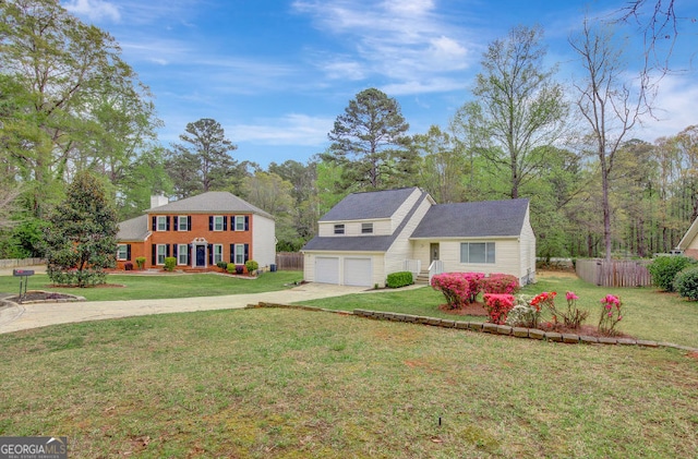 view of front of home featuring driveway, fence, and a front lawn
