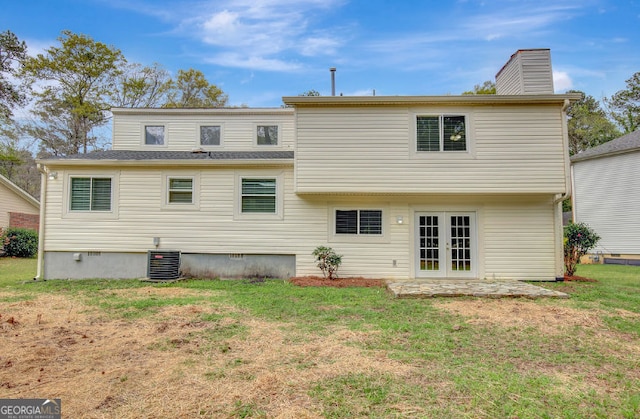 rear view of property with french doors, central AC, a chimney, and a lawn