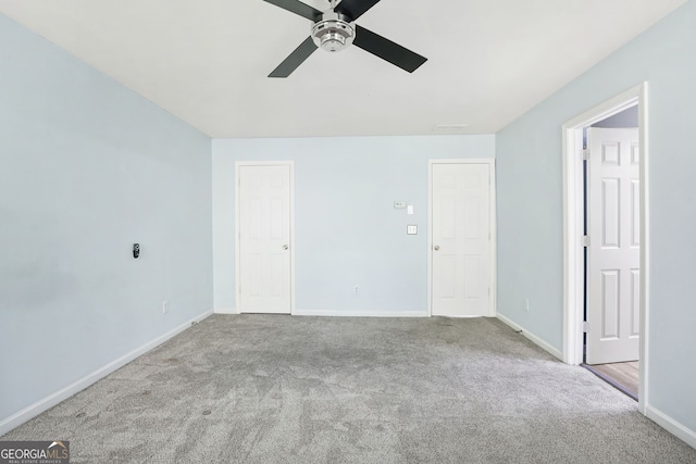 carpeted empty room with ceiling fan and baseboards