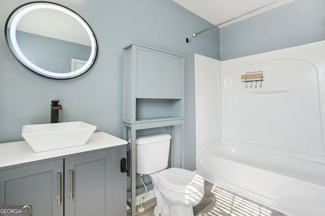 full bath featuring vanity, washtub / shower combination, and toilet