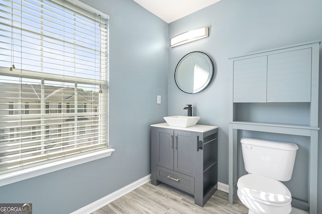 bathroom featuring vanity, baseboards, toilet, and wood finished floors
