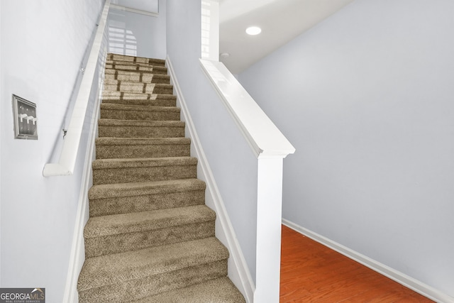 stairway featuring baseboards and wood finished floors