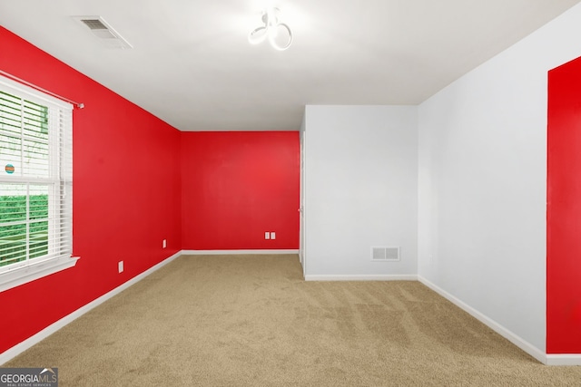 spare room with visible vents, carpet flooring, and baseboards