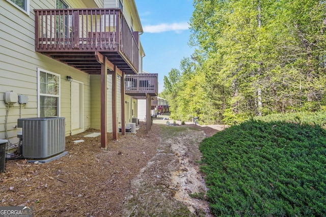 view of yard with a deck and central AC