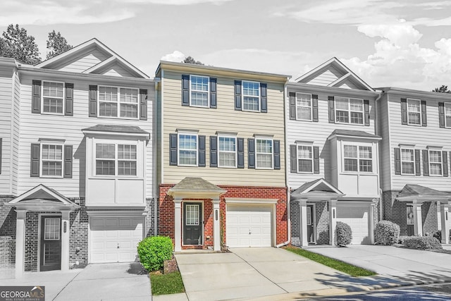 multi unit property with brick siding, a garage, and driveway