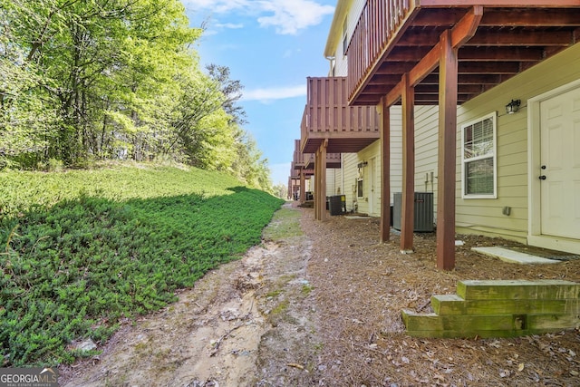 view of yard with a deck and central AC