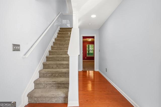 staircase with baseboards, recessed lighting, and wood finished floors