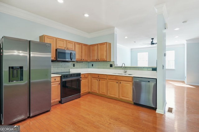 kitchen with visible vents, appliances with stainless steel finishes, a sink, light countertops, and ornamental molding