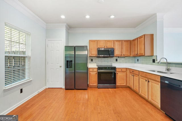 kitchen featuring a sink, light countertops, ornamental molding, and stainless steel appliances