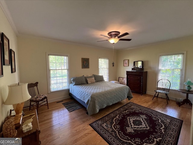 135 Southlake Dr, Moultrie, GA 31768 - bedroom with multiple windows, light wood finished floors, ornamental molding, baseboards, and ceiling fan