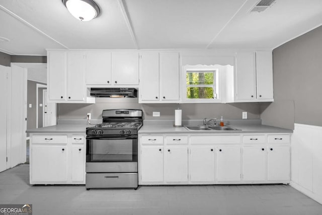 kitchen with stainless steel gas range, under cabinet range hood, a sink, and light countertops
