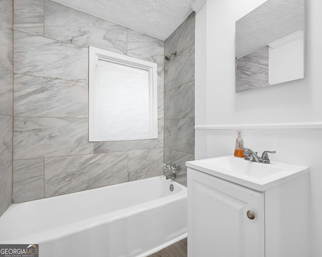 full bathroom featuring a textured ceiling, vanity, bathtub / shower combination, and wood finished floors