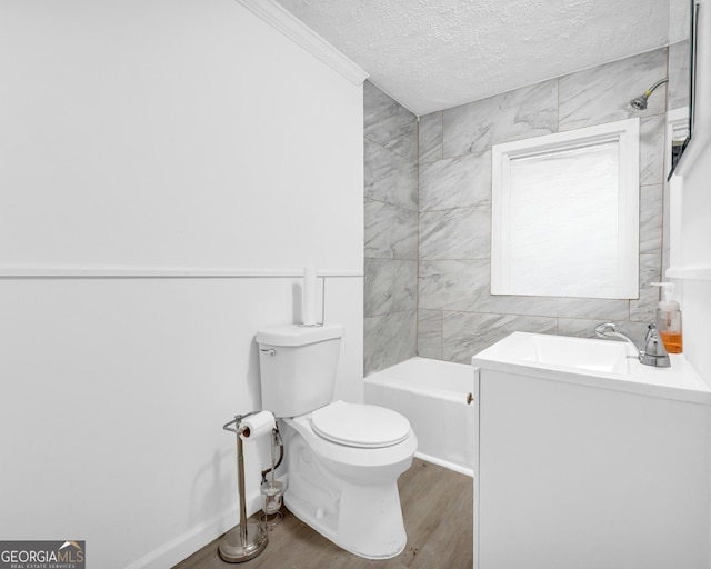 bathroom featuring a sink, a textured ceiling, wood finished floors, toilet, and a bathtub