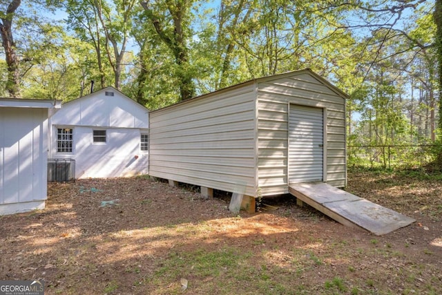 view of shed with central AC unit and fence