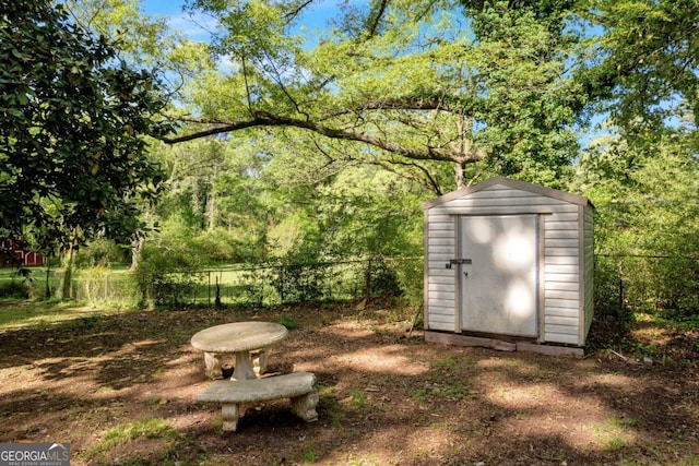 view of yard featuring fence, an outbuilding, and a shed