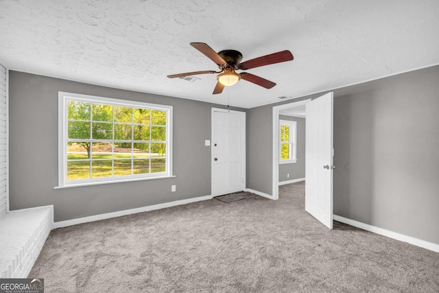 entrance foyer featuring a ceiling fan, carpet, baseboards, and a textured ceiling