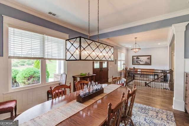dining room featuring visible vents, crown molding, and wood finished floors