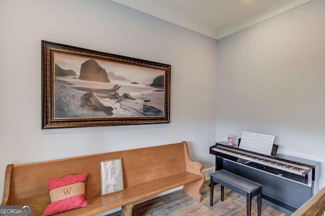 living area with baseboards, crown molding, and wood finished floors