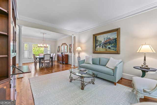 6140 Rachel Rdg, Peachtree Corners, GA 30092 - living room featuring ornate columns, a chandelier, wood finished floors, and ornamental molding