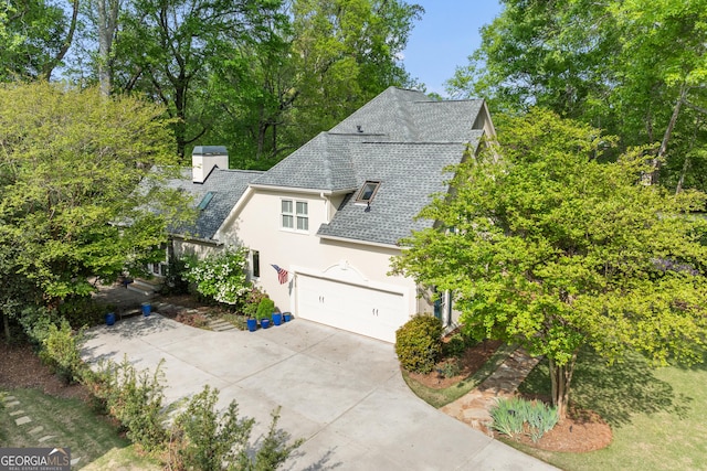 6140 Rachel Rdg, Peachtree Corners, GA 30092 - view of property exterior featuring stucco siding, driveway, a shingled roof, a chimney, and an attached garage