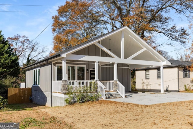 view of front of house featuring a carport, fence, and covered porch