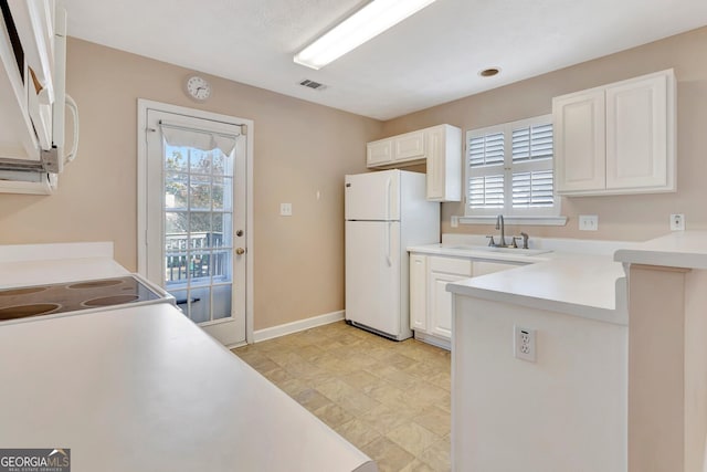 kitchen featuring a sink, white appliances, visible vents, and plenty of natural light