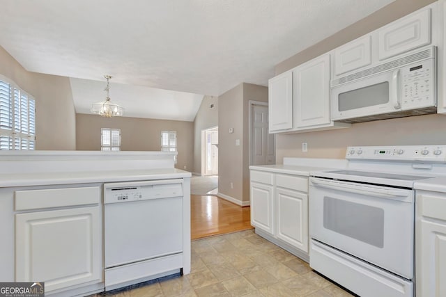 kitchen featuring a chandelier, plenty of natural light, white appliances, white cabinetry, and light countertops