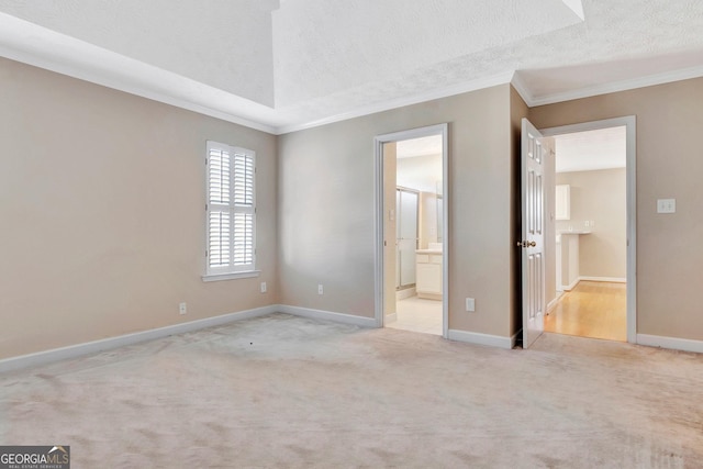 unfurnished bedroom with a textured ceiling, baseboards, ornamental molding, and carpet floors