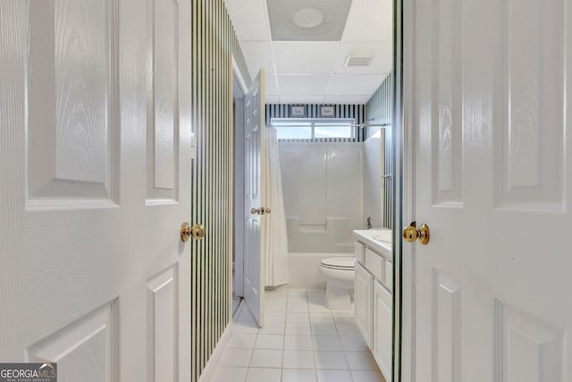 bathroom with toilet, bathtub / shower combination, vanity, tile patterned floors, and a drop ceiling