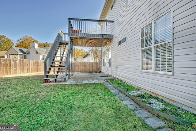view of yard with a fenced backyard, a patio, and stairs