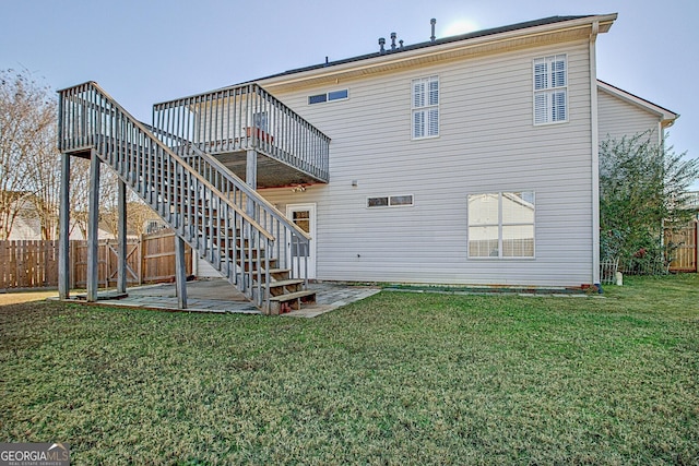 back of house with a wooden deck, a lawn, stairway, a patio area, and fence