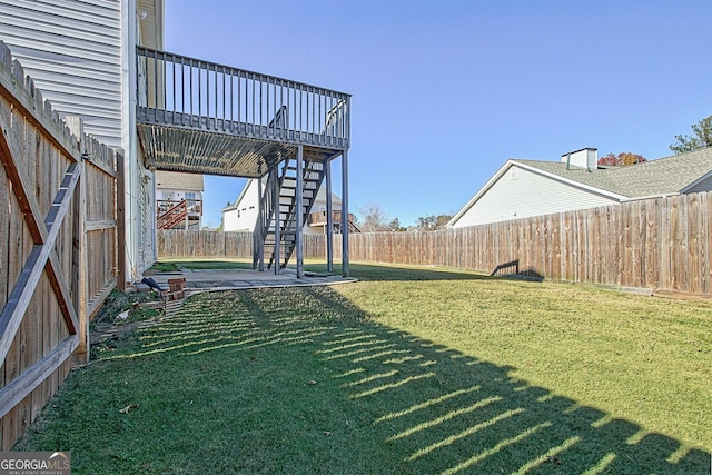 view of yard featuring stairs, a fenced backyard, and a wooden deck