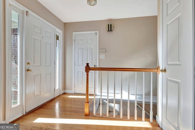 foyer with light wood finished floors and baseboards