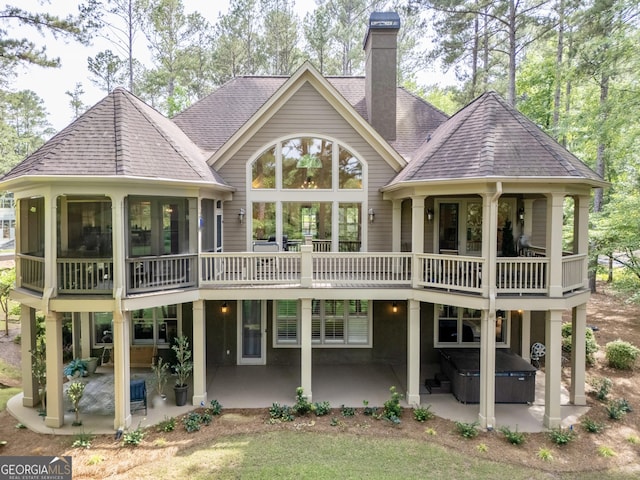 1021 Homestead, Greensboro, GA 30642 - back of house featuring a hot tub, a patio, a chimney, and roof with shingles