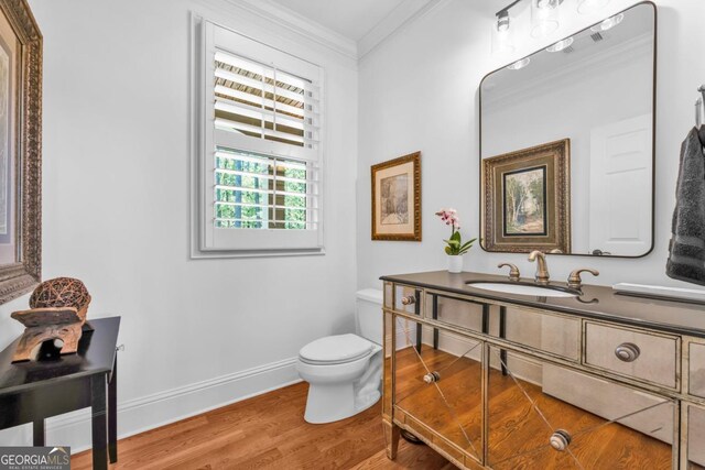 1021 Homestead, Greensboro, GA 30642 - bathroom featuring ornamental molding, toilet, wood finished floors, vanity, and baseboards