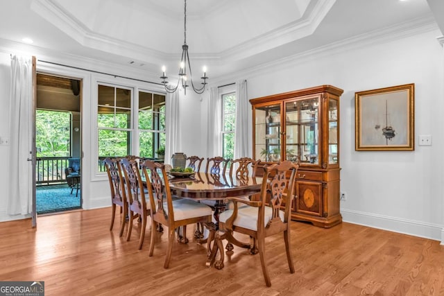 1021 Homestead, Greensboro, GA 30642 - dining area featuring light wood finished floors, a chandelier, ornamental molding, and a tray ceiling