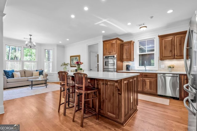 1021 Homestead, Greensboro, GA 30642 - kitchen featuring stainless steel appliances, a kitchen island, crown molding, light countertops, and recessed lighting
