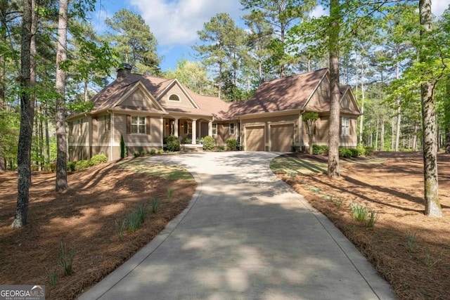 1021 Homestead, Greensboro, GA 30642 - shingle-style home with an attached garage, concrete driveway, covered porch, and a chimney